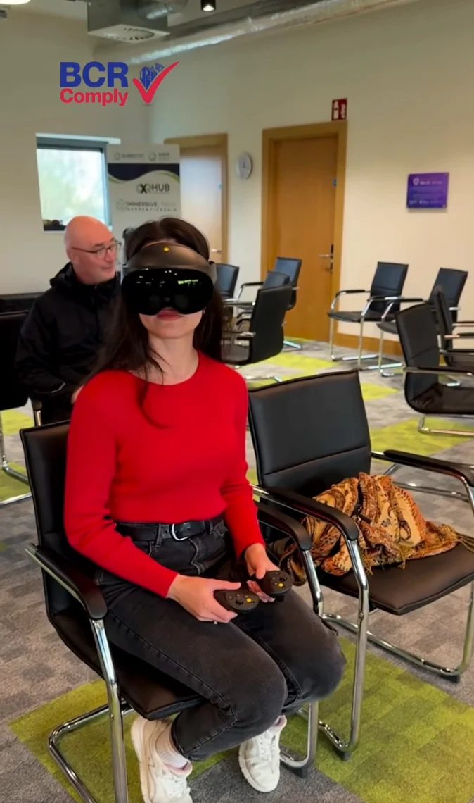 A seated participant wearing a headset and holding a controller at XRHub