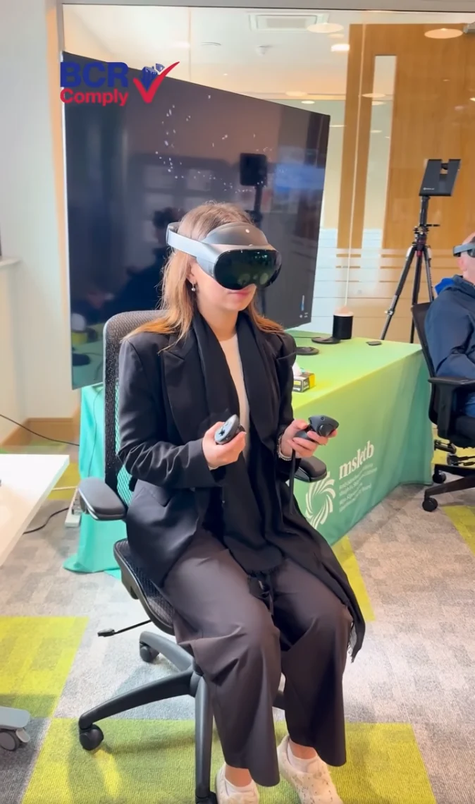 A seated participant trying an immersive headset with handheld controllers