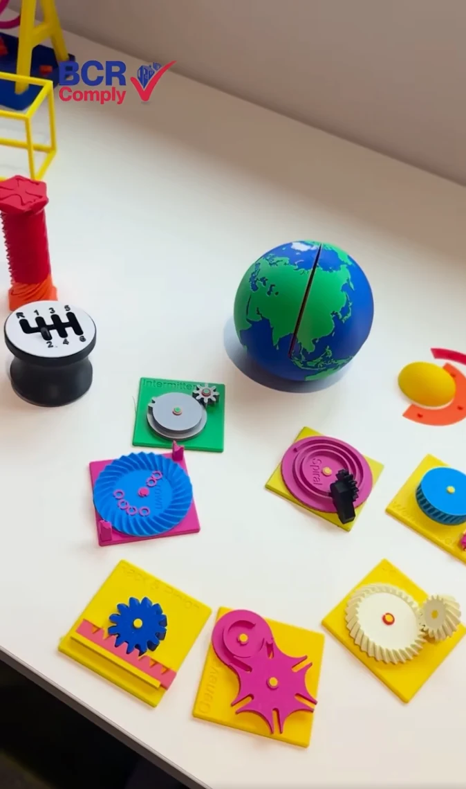 Colourful printed models including a globe and mechanical shapes on a table